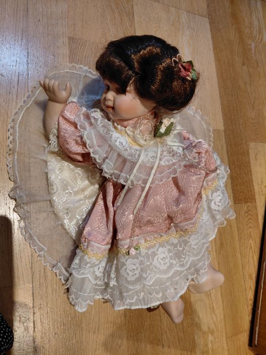 Boneca de porcelana com almofada