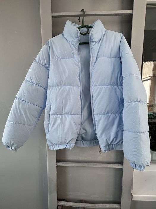 Небесного кольору тепла куртка пуфер