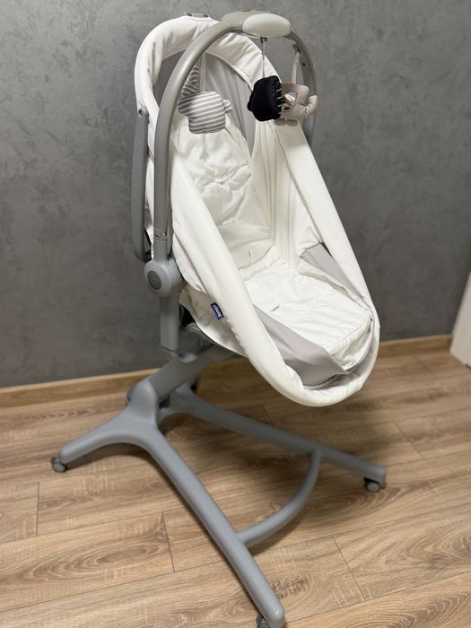 Кроватка-стульчик Chicco Baby Hug Air 4-в-1 в белом цвете с сетчатыми боковинами для вентиляции.