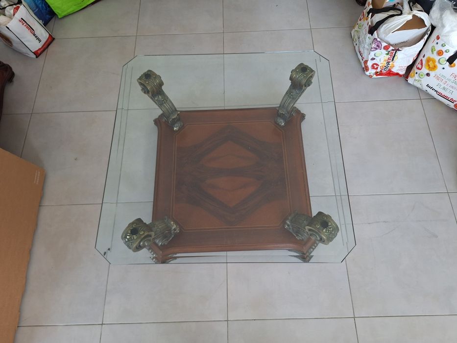 Mesa de centro clássica com tampo de cristal.