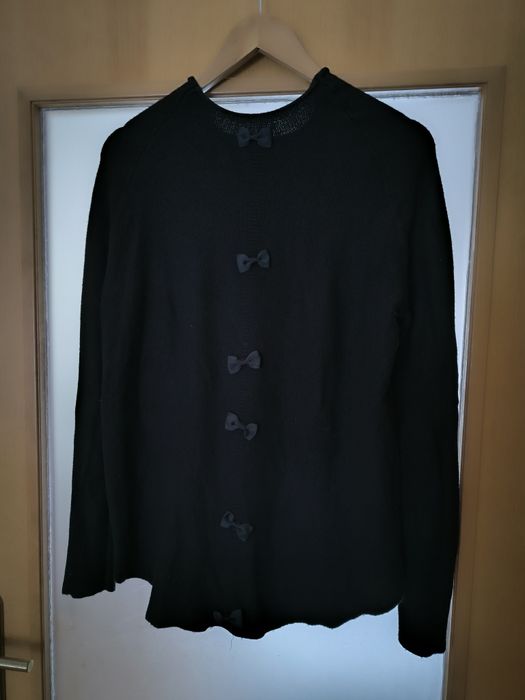 Camisola preta pedras de brilho e abertura com transparência atrás.