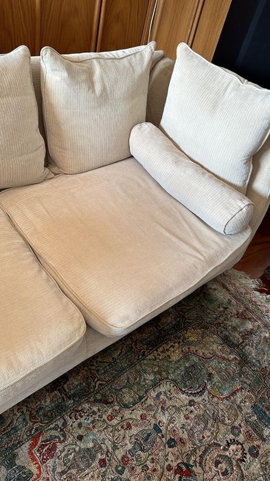 Sófá em tecido com almofadões de penas.