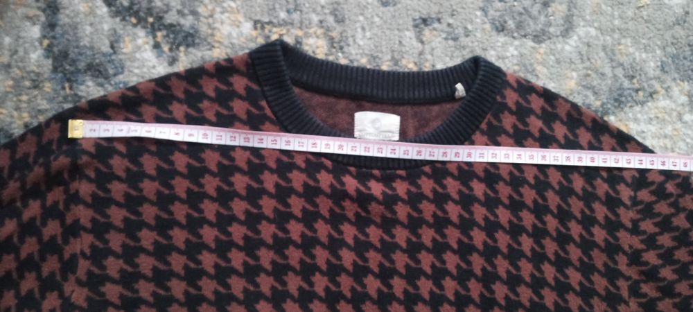 Bordowy sweter w czarną pepitkę.