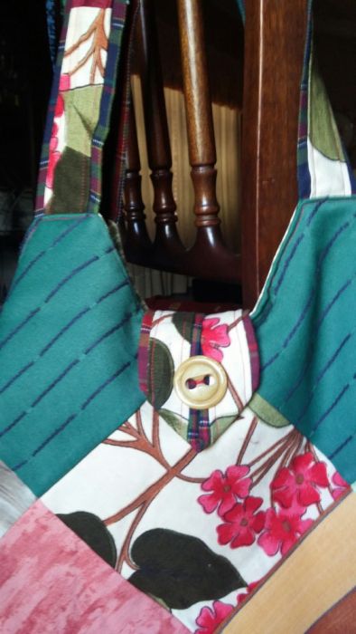 saco/mala com quadrados de tecido. Tem bolsos interiores