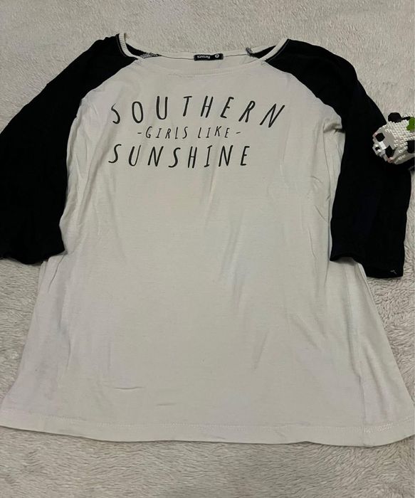 biala koszulka z napisami z czarnymi rekawami