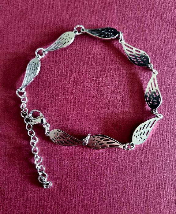 Conjunto prateado (colar e pulseira), em aço,  com asas de anjo.
