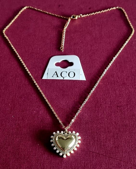 Colar dourado, em aço, com pingente formato coração rodeado de zirconias e pérolas