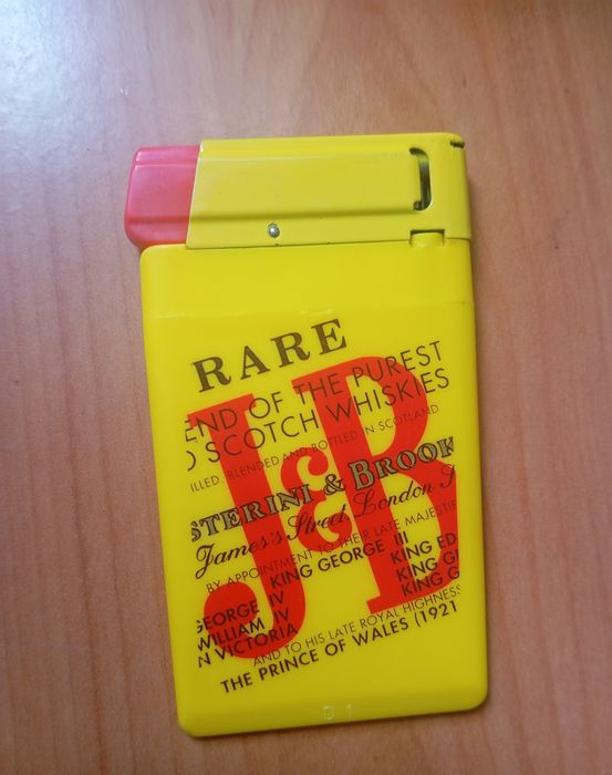 Isqueiro e caneta da marca J&B.