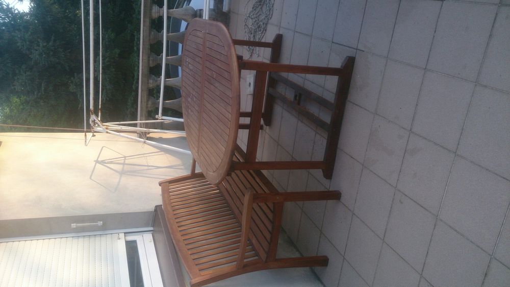 Stół ogrodowy z ławą i parasolem.