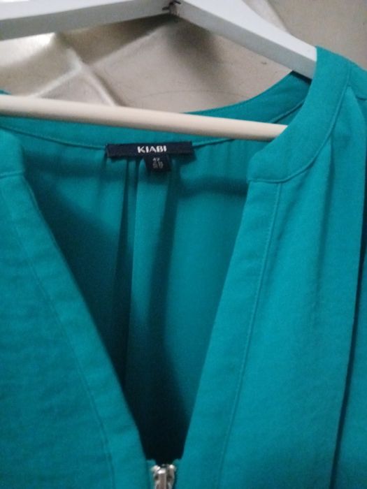 Vestido azul esverdeado, veste pequeno, ligeiramante abaixo do joelho,