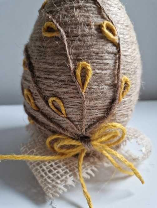 Jajko wielkanocne ręcznie robione z juty na dekoracyjnym stojaku