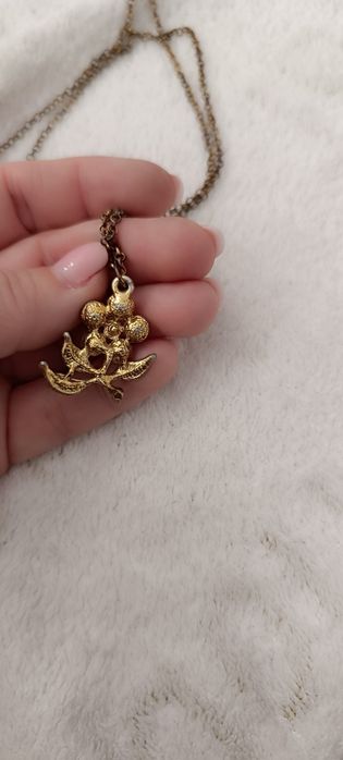 Fio dourado com pendente flor azul e brilhantes