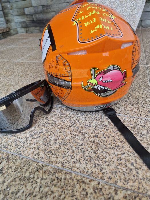 capacete de motocross laranja e amarelo com gráficos de dentes de tubarão