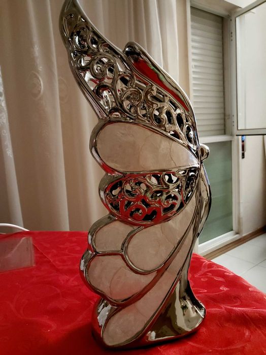Escultura em metal em forma de borboleta rendilhado com detalhes com textura similar a madrepérola