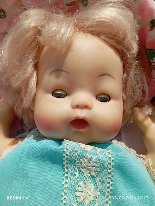 Boneca antiga num berço de vime