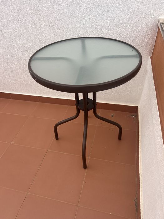 Mesa exterior redonda em ferro e vidro