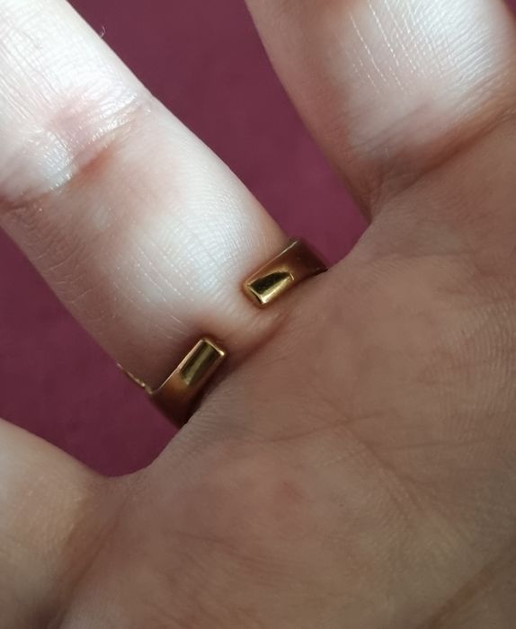 Anel dourado, em aço, com pedrinha redonda lilás. Ajustável