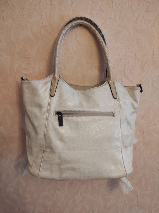 Світло бежева сумка з штучної шкіри з бахромою.