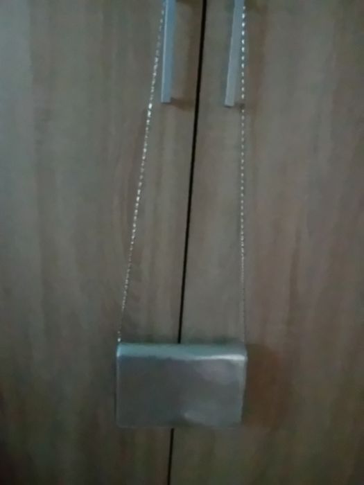 Torebka damska koloru srebrnego z z dłuszym paskiem srebrnym.