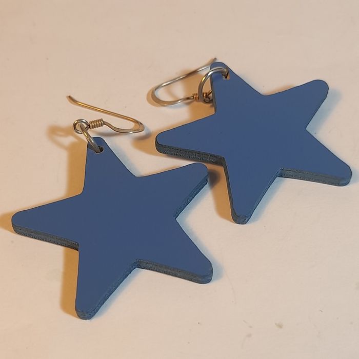 Brincos em Madeira com design de estrelas.