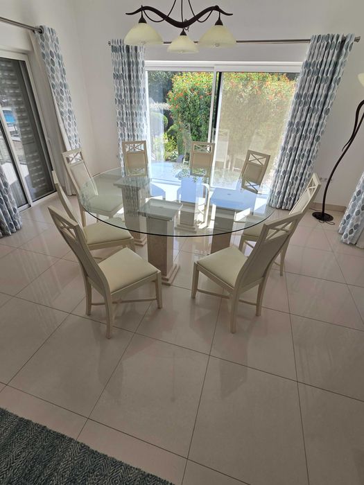 Mesa de jantar de vidro com pilares de mármore