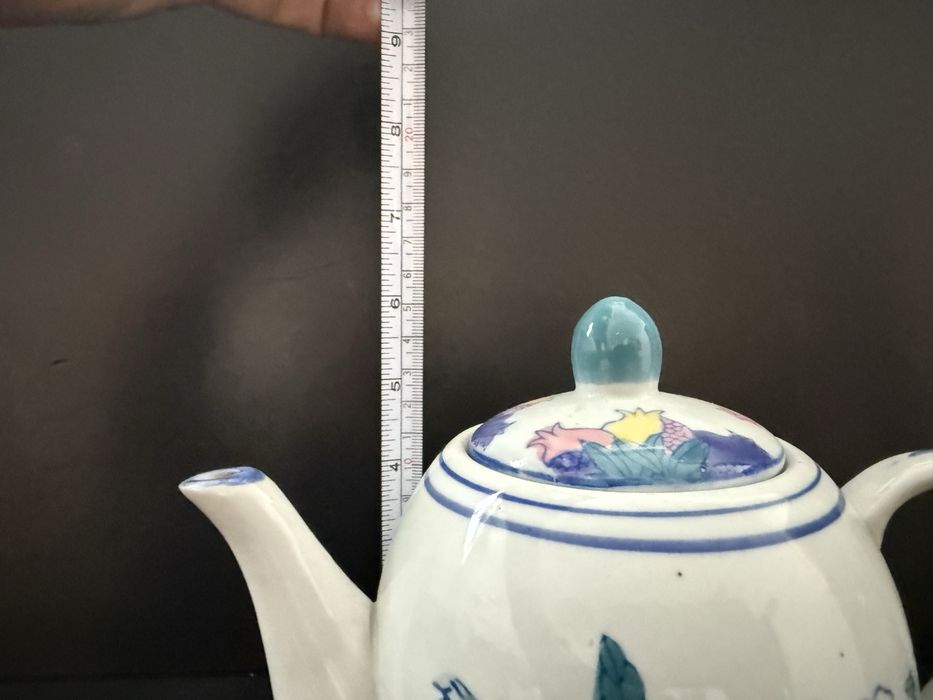 bule de chá de porcelana com uma decoração de frutas pintadas à mão.