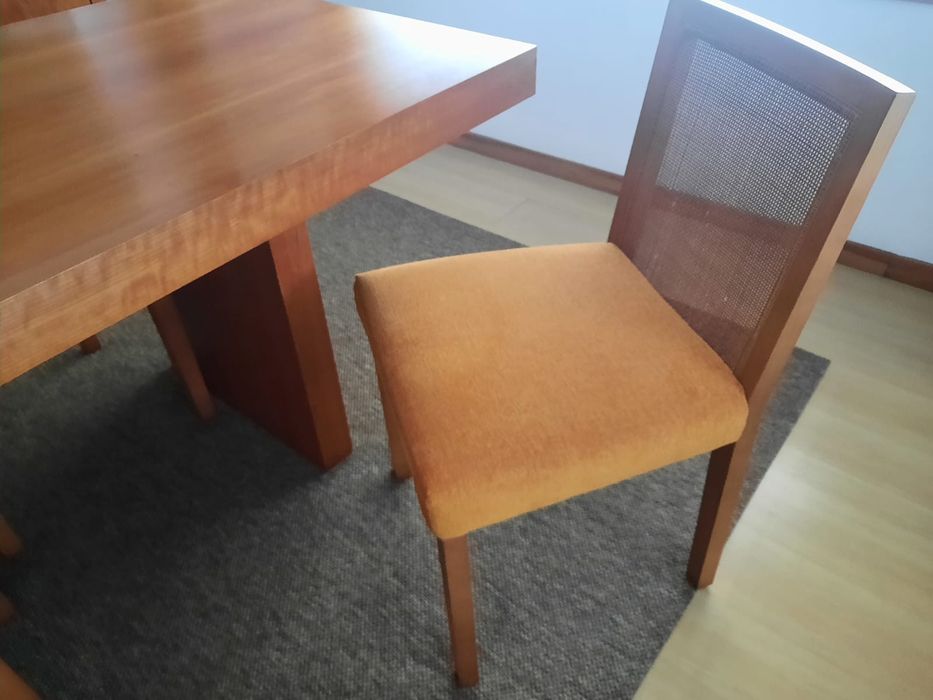 Mesa de madeira e cadeiras almofadadas