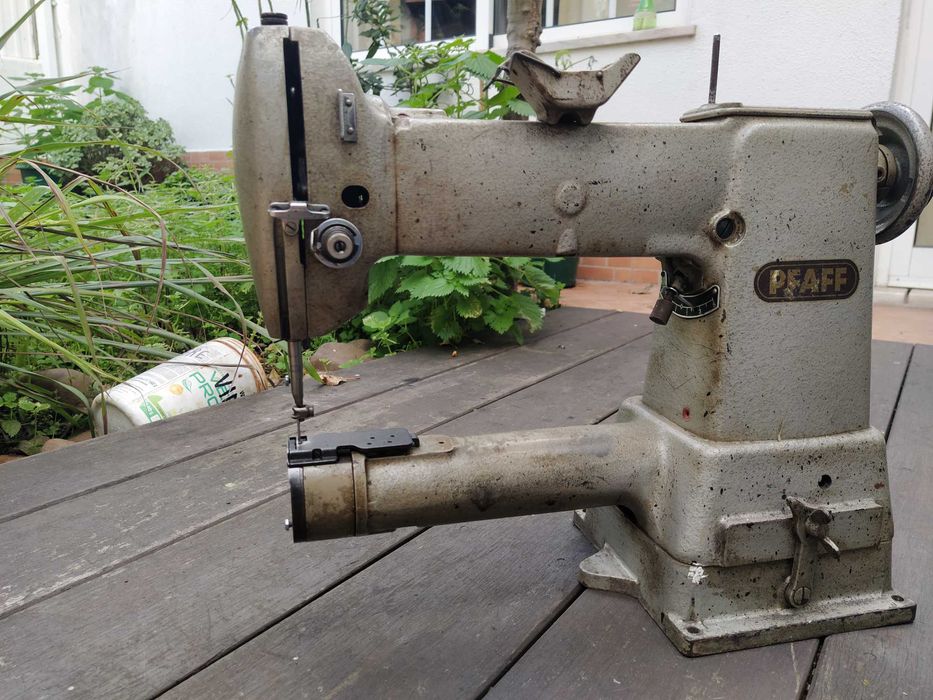 Uma máquina de braço Singer para coser pele e tecidos grossos .