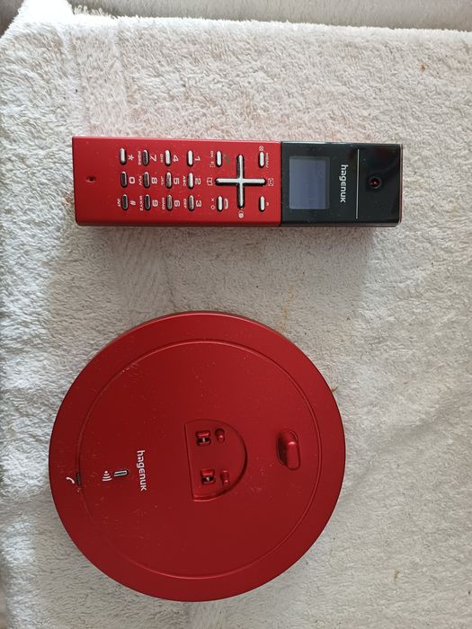 Vendo telefone fixo sem fios da marca Hagenuk, tecnologia DECT, em cor vermelha com detalhes a preto. Design moderno e compacto.