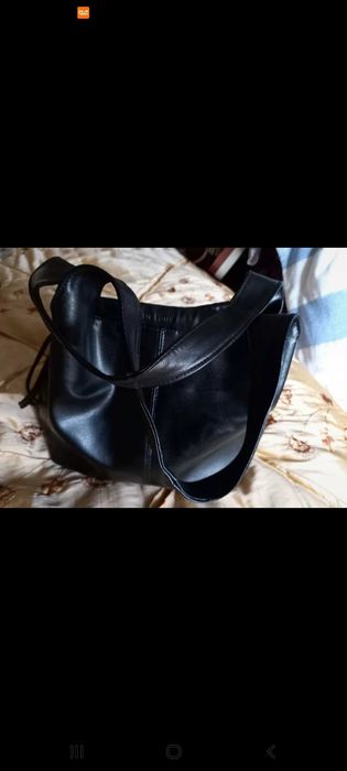 Mala preta, com mola e fios laterais para fechar.