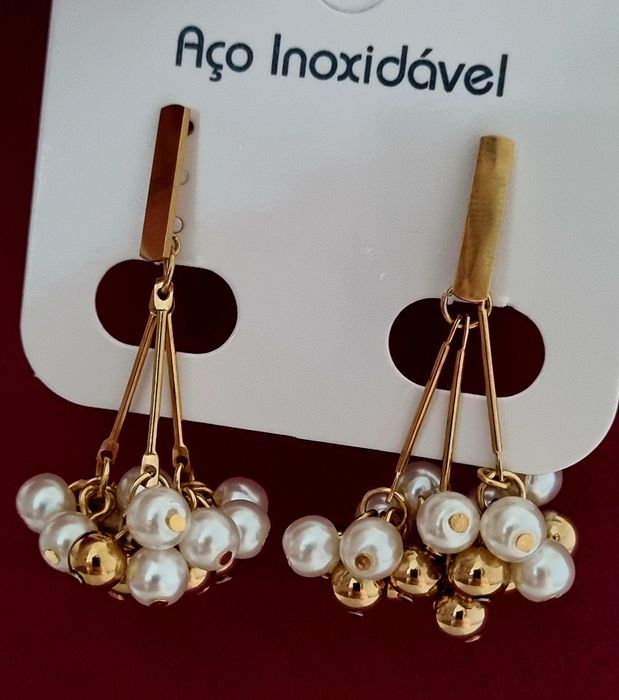 Brincos dourados, em aço, com muitas pérolas e bolinhas douradas ao penduro. De pico.