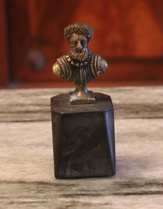 Busto de Luís Vaz de Camões com 12cm de altura, bronze sobre mármore.