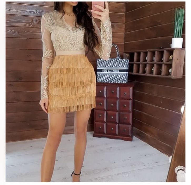 жовта сукня із кружевним верхом та юбкою із бахроми.