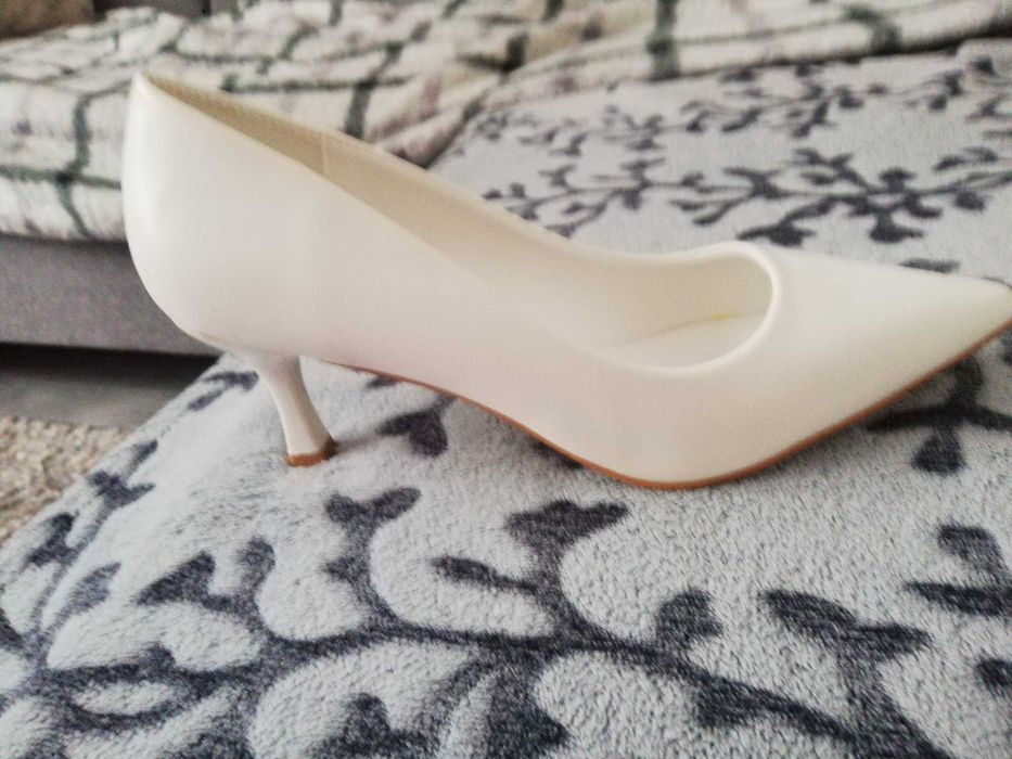 Białe szpilki damskie.