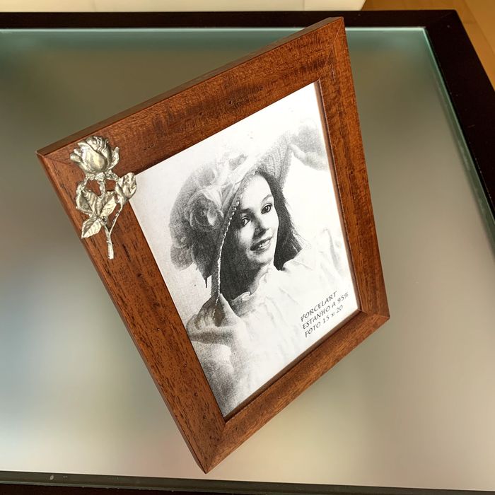 Wooden frame with embossed design and silver metallic detail.