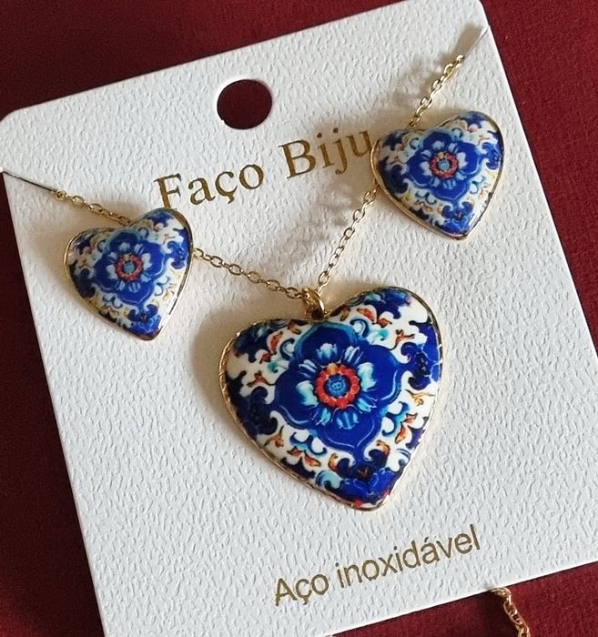 Conjunto dourado, em aço, com corações de Viana em tons de azul.