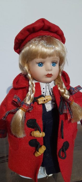 Boneca loiça e pano, com suporte em metal