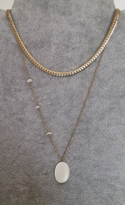 Colar duplo dourado, em aço, com pingente em madrepérola natural.