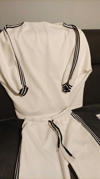 Nowy dres damski kremowy z czarnymi lamowkami.