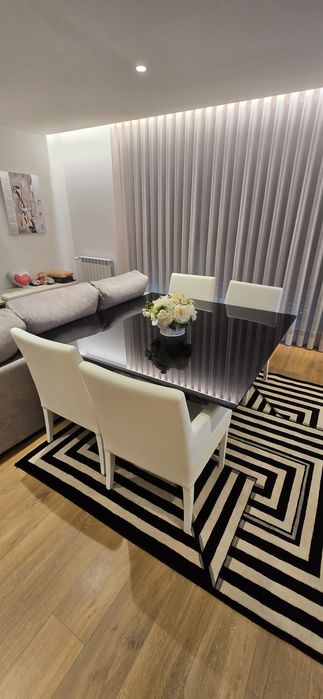 Mesa de jantar com cadeiras e tapete