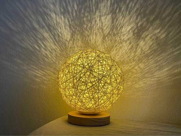 Candeeiro de mesa com esfera em fibra natural e base em madeira