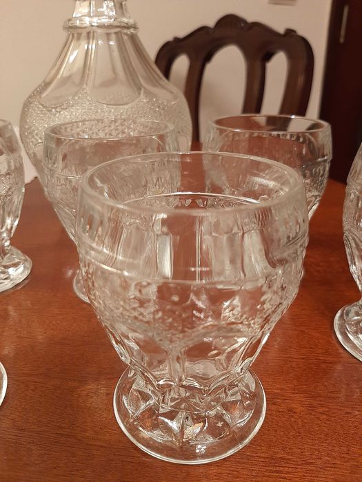 Garrafa antiga de vidro e seis copos