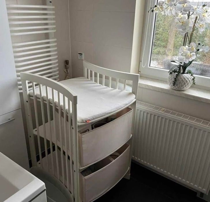 Przewijak Stokke z pojemnymi organizerami. Białe drewno.