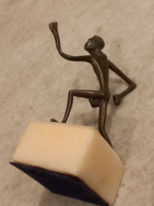 Estatueta em metal com suporte em pedra
