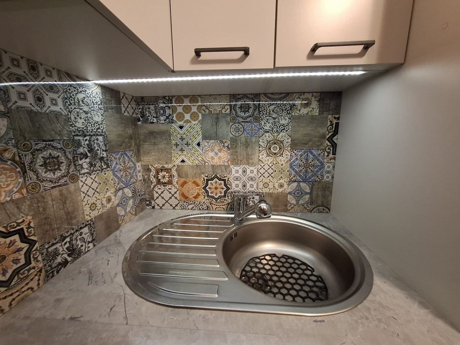 Zabudowa kuchenna ze stołem i sprzętem AGD