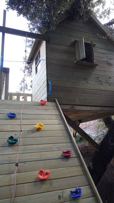Casinha na árvore com parede de escalada