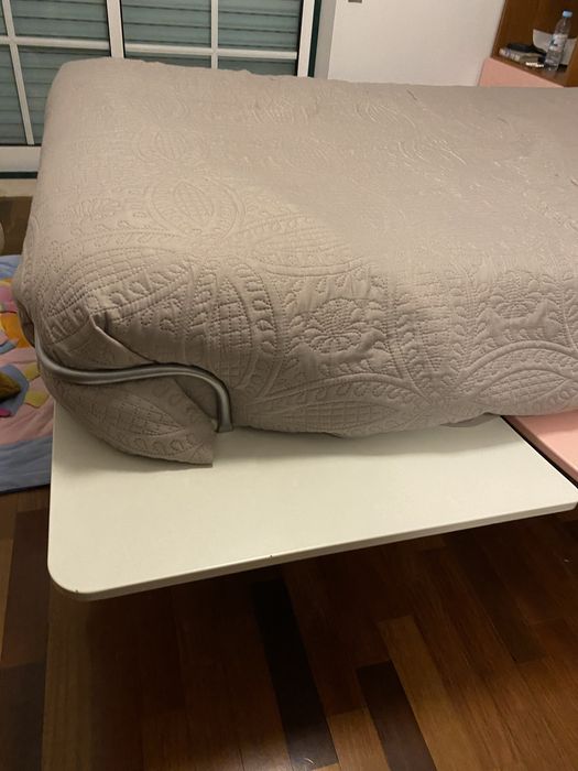 Cama em tons rosa e branco com suporte lateral
