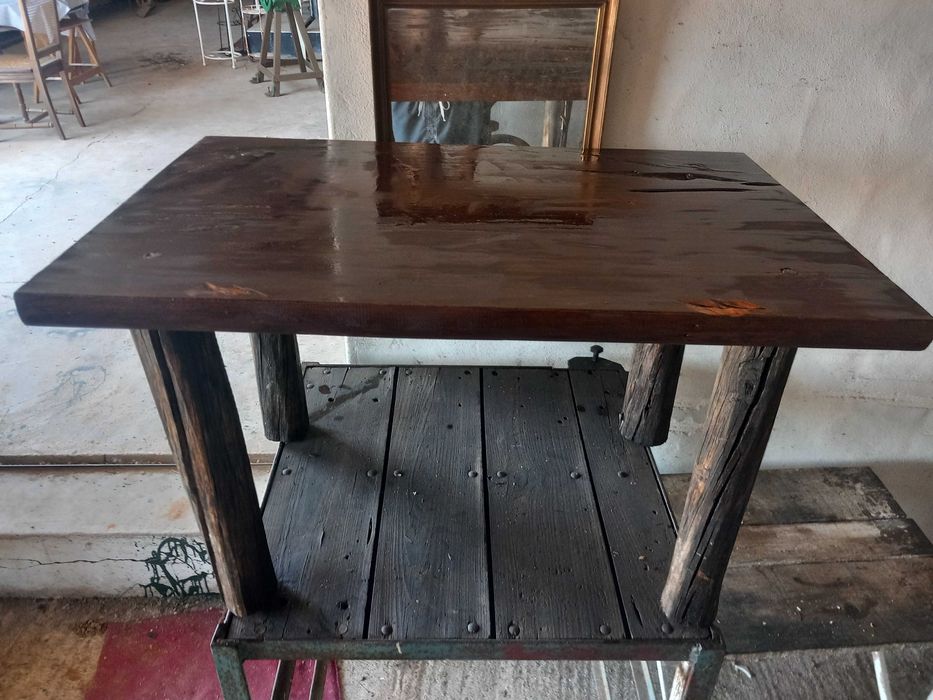Mesa rústica de madeira maciça, antiga, tampo retangular espesso, pernas robustas em troncos roliços escurecidos