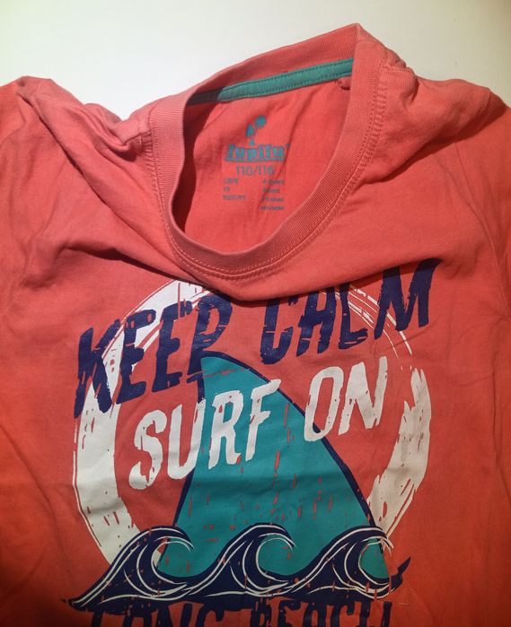 Dziecięca koszulka marki Lupilu w kolorze koralowym z nadrukiem "Keep Calm Surf On Long Beach"