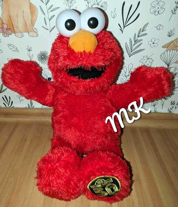 Elmo śmieje się i mówi.